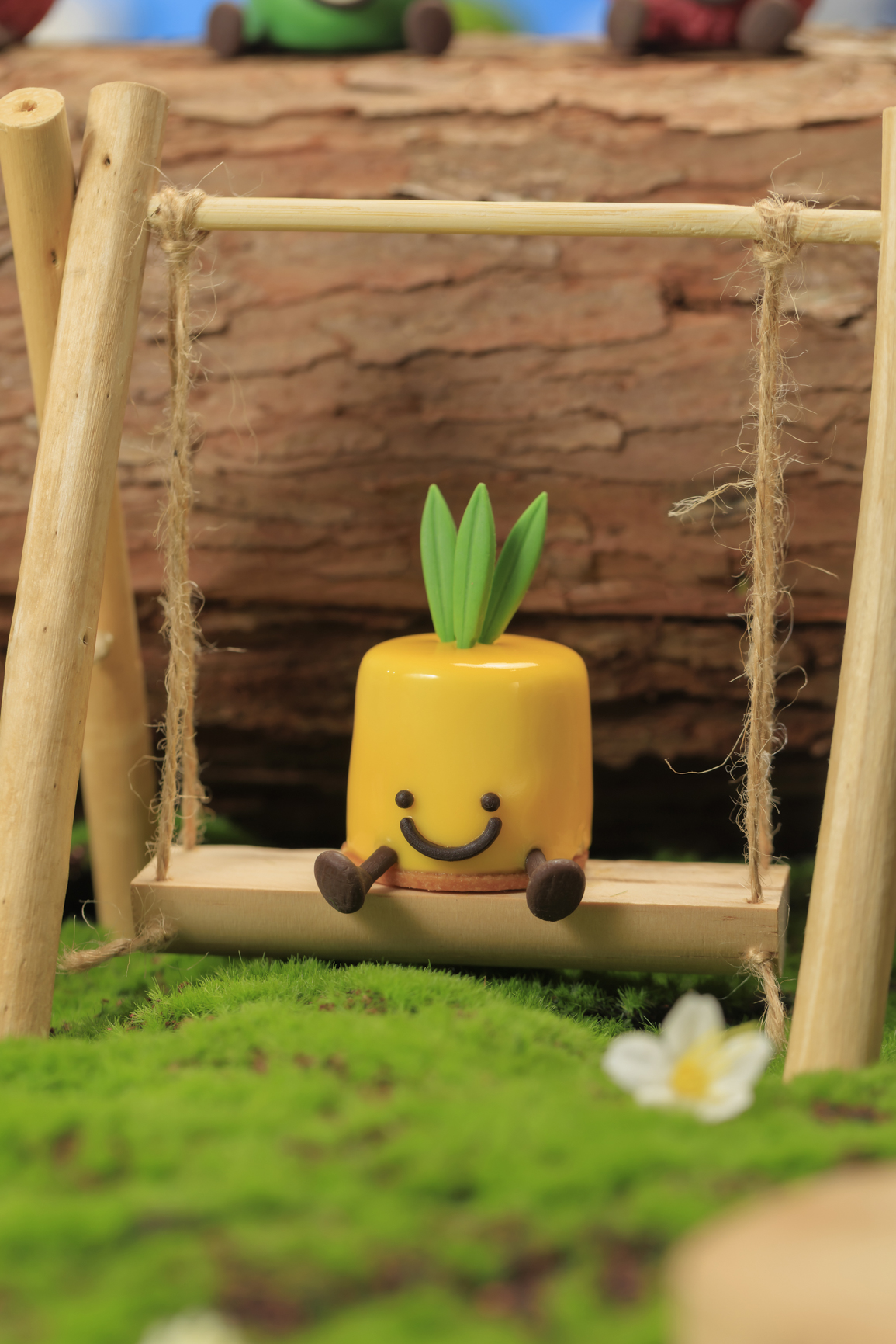 Mango pineapple mousse with a shiny glaze and smiley face, part of the Fruitylicious set.