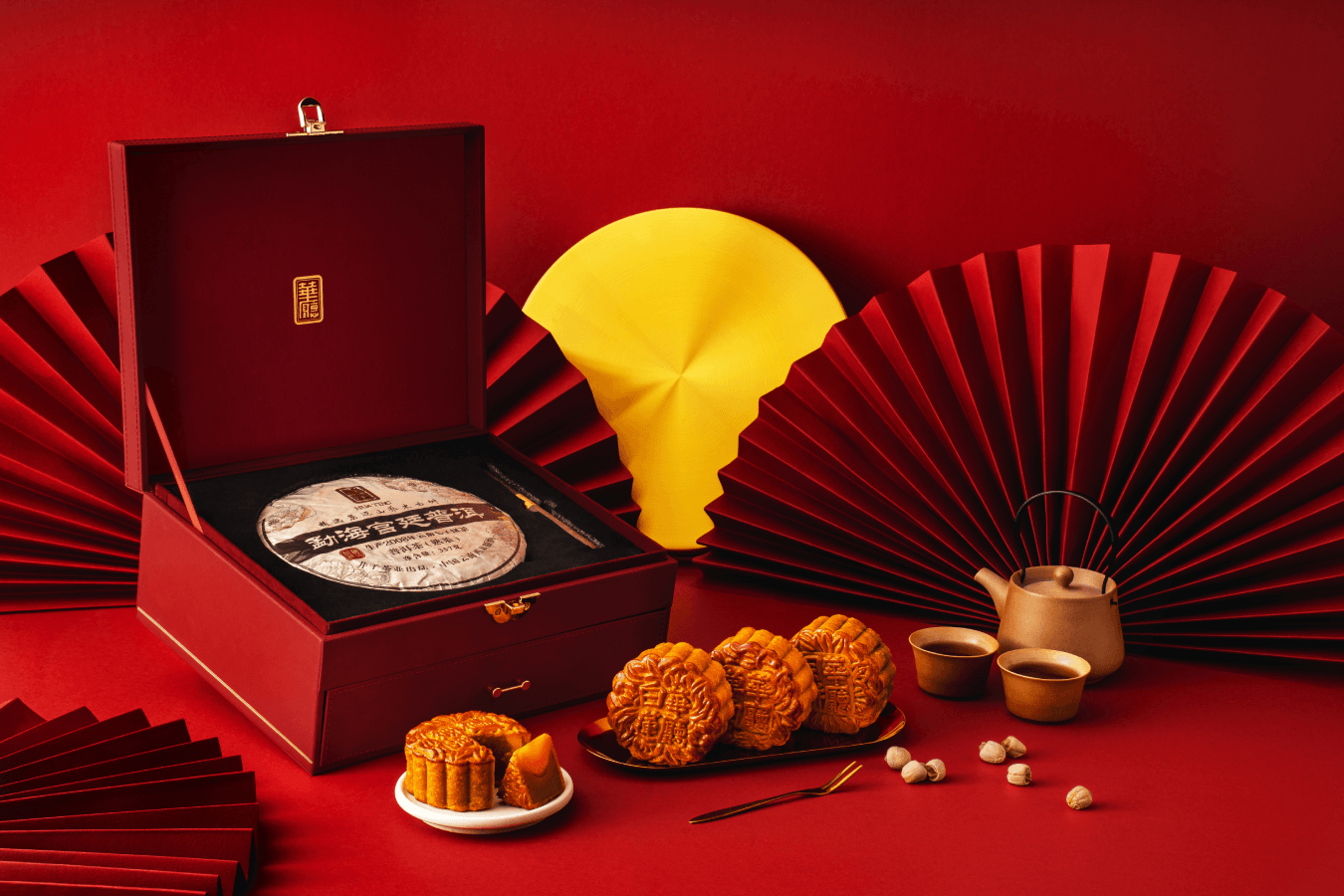 Baked mooncakes and a pressed tea cake in the red Hua Ting gift box.