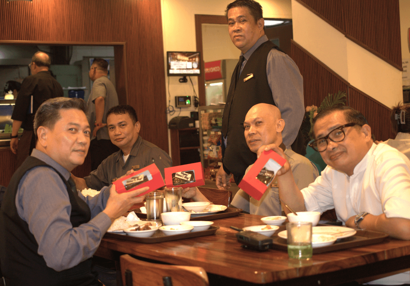 Colleagues raise their Father's Day gift boxes at The Heritage Hotel Manila.