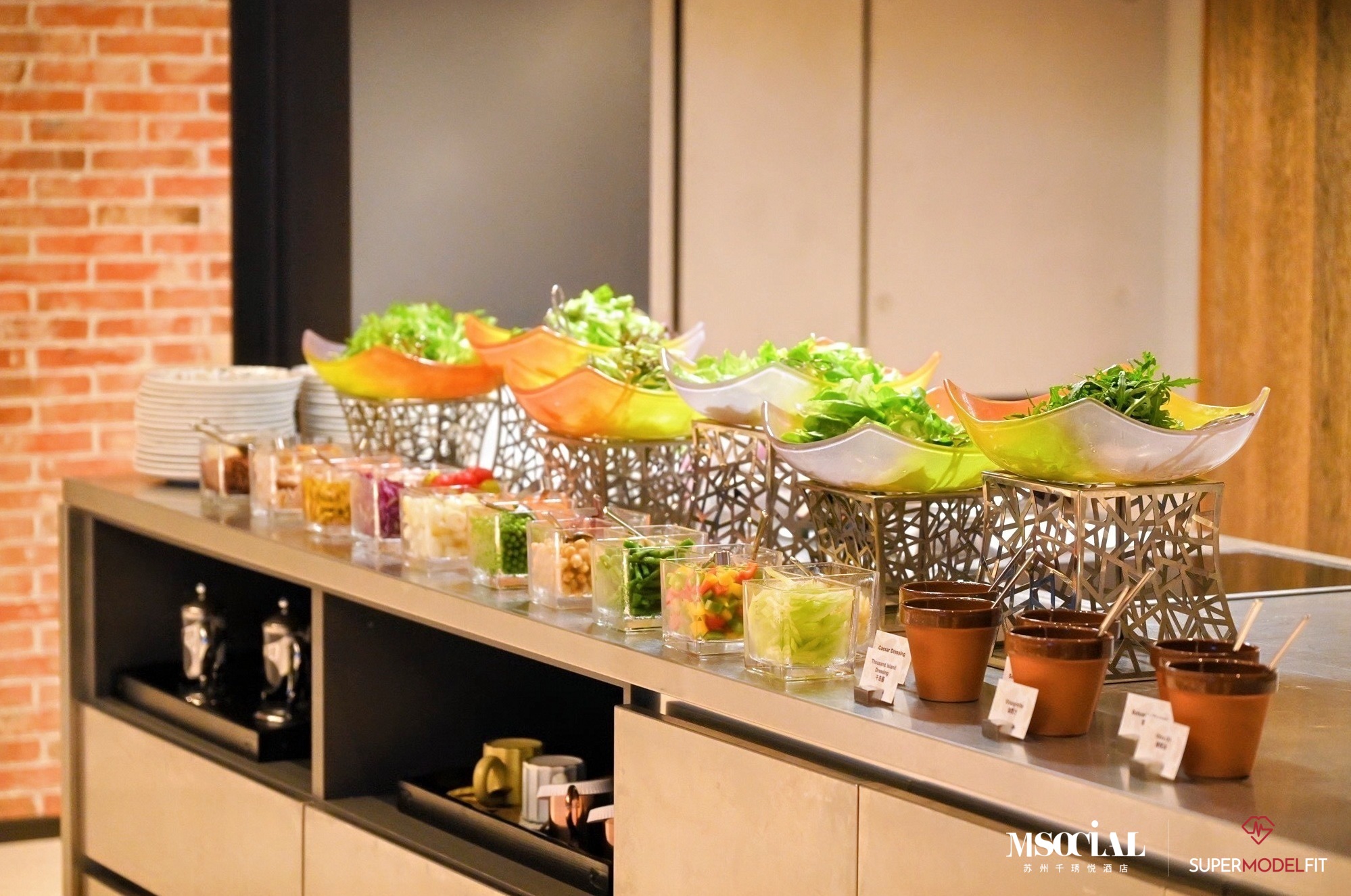 A selection of fresh greens accompanied by an assortment of dressings and condiments at the healthy salad bar.