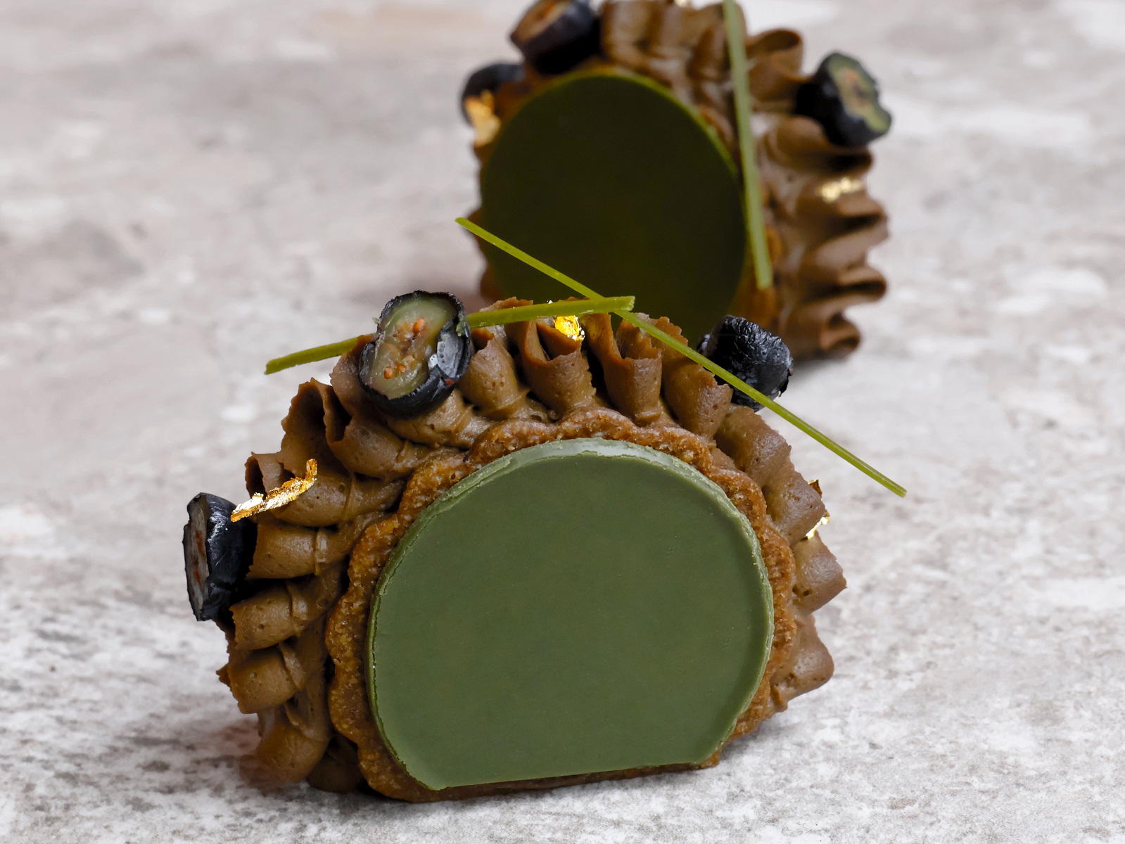 The Oolong Sesame Mochi Pastry, its green centre finished with gold leaf.