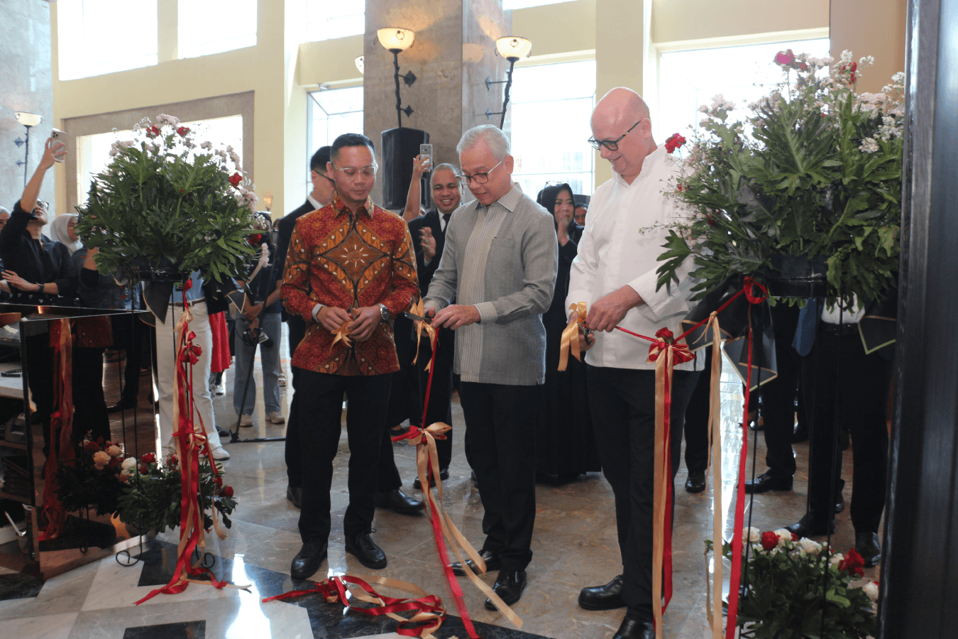 Manny Mercado, Eric Costille and Allova Herling Mengko cut the ribbon at Cafe Sirih.