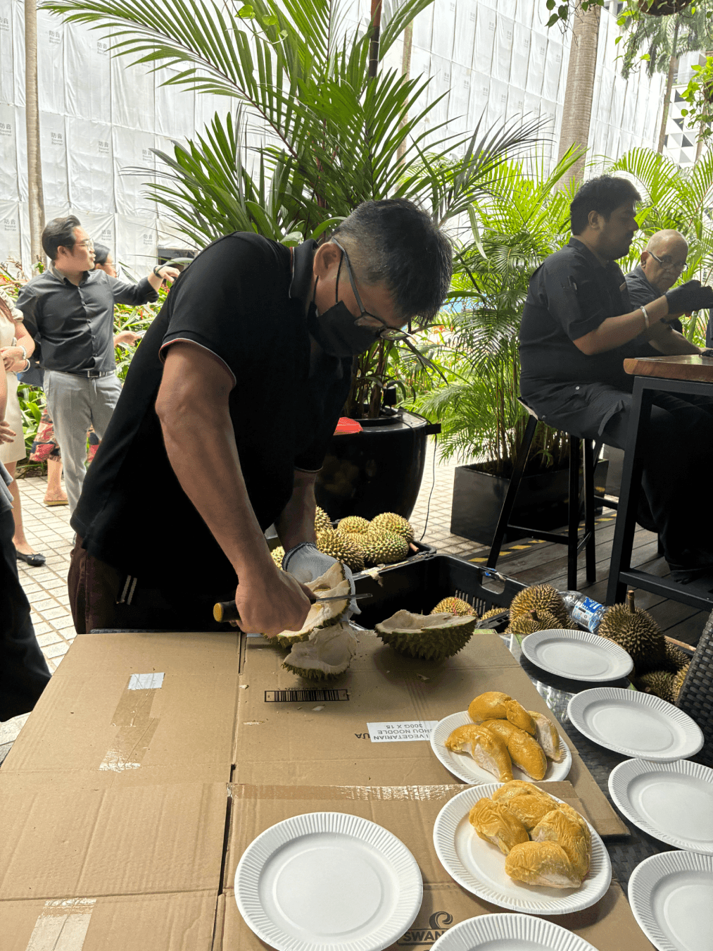 Opening up bundles of durians for eager team members at M Bar.