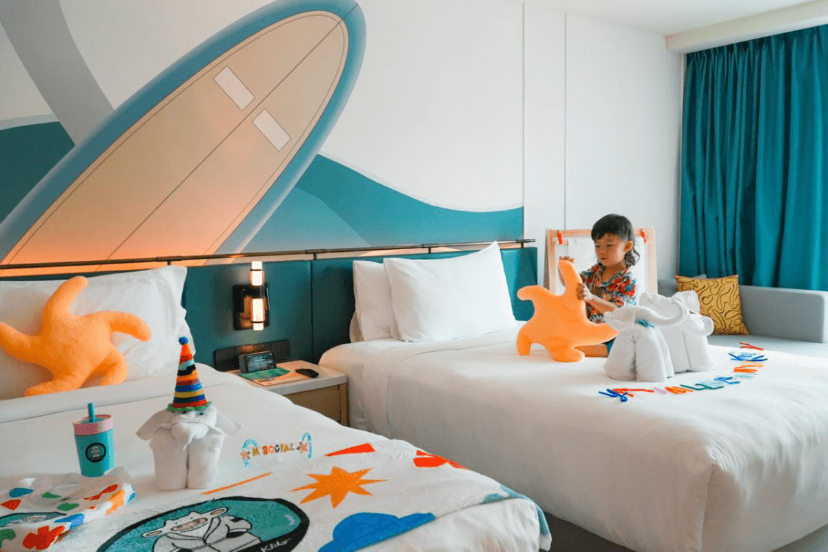 A room dressed for young explorers, with surfboard headboard, starfish cushions and play mat.