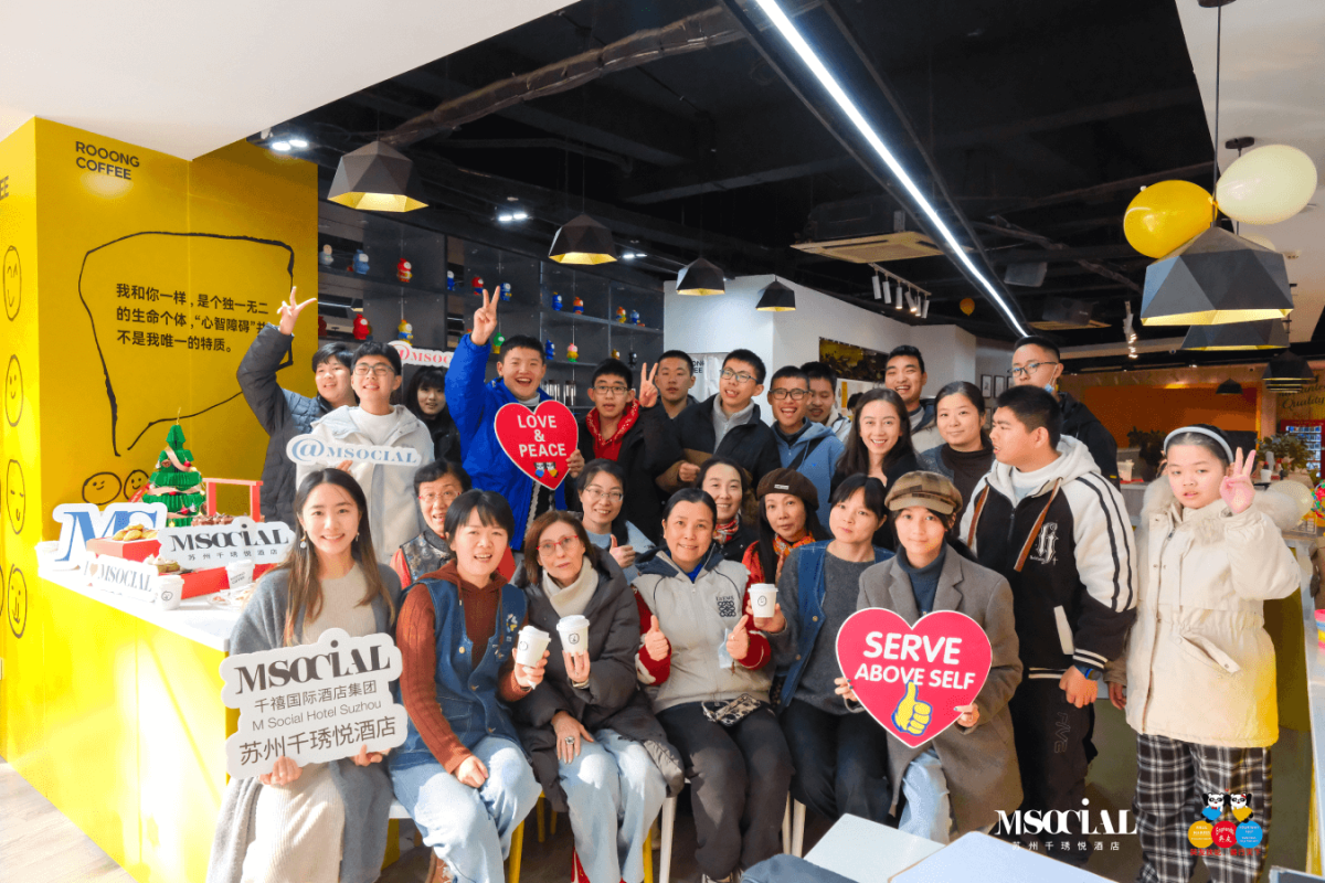The M Social Hotel Suzhou team and guests celebrating together, embodying the "Serve Above Self" philosophy