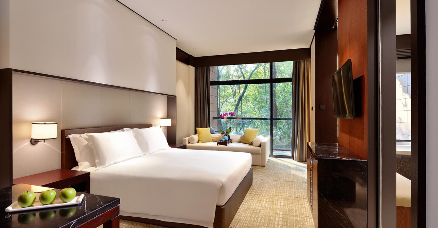 The Deluxe Room forms part of the Longjing tea room package at Millennium Resort Hangzhou, where guests wake to views of the tea-growing landscape before heading into the fields to pick fresh buds.